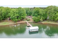 Aerial view of a lakefront property with a dock and boathouse, surrounded by lush greenery at 4798 Lynwood Rd, Sherrills Ford, NC 28673