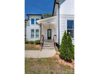 Charming home entrance features wooden steps, glass-paneled door, and a well-maintained landscape at 5028 Lewis Rd, Gastonia, NC 28052
