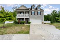 Charming two-story home with a welcoming front porch, attached garage, and well-maintained landscaping at 6040 Fazio Ct, Harrisburg, NC 28075