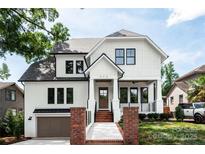 Charming two-story home showcasing a white exterior, black trim windows, and a welcoming front porch at 632 Dorothy Dr, Charlotte, NC 28203