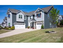Charming home with a three-car garage, stone accents, manicured lawn, and mature landscaping at 990 Nw Capwalk Nw Rd # 138, Concord, NC 28027