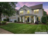 Charming two-story home featuring a manicured lawn and inviting front porch with classic columns at 125 N Wendover Trce, Mooresville, NC 28117