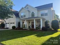 Charming two-story home with a beautifully landscaped front yard and welcoming front porch with columns at 125 N Wendover Trce, Mooresville, NC 28117