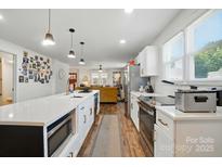 Bright kitchen featuring a center island, stainless steel appliances, and an open floor plan to the living area at 139 5Th St, Huntersville, NC 28078