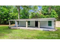 Charming single-story home with a covered front porch and brick-accented support beams, nestled amongst lush trees at 143 Phifer Cir, Kings Mountain, NC 28086