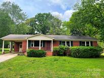 Charming single-story red brick home with a well-manicured green lawn and lush landscaping at 1824 Ebinport Rd, Rock Hill, SC 29732