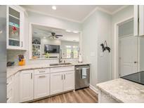 Bright kitchen featuring white cabinets, stainless steel appliances, granite counters, and open view to the living area at 18524 Mizzenmast Ave, Cornelius, NC 28031
