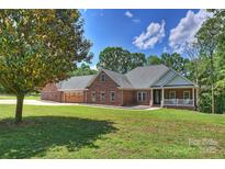 Charming single-story brick home featuring a well-manicured lawn and a welcoming front porch with a white railing at 3009 Brooks Mill Ln, Wingate, NC 28174