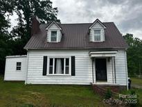 Charming home with a brown roof, white siding, black shutters, and a cozy front porch at 3101 Hickory Hwy, Statesville, NC 28677