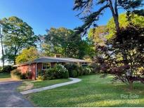 Charming brick home with lush landscaping and a well-maintained lawn at 5209 Markay St, Matthews, NC 28105
