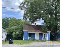 Charming blue home featuring a cozy front porch and a well-maintained gravel yard at 739 Old Charlotte Sw Rd, Concord, NC 28027