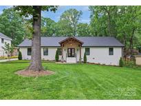 Charming single story home with a freshly manicured lawn and mature tree creates lovely curb appeal at 1118 Crestbrook Dr, Charlotte, NC 28211