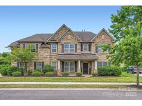 Charming brick home featuring a well-manicured lawn and traditional design elements under a clear blue sky at 117 Fellspoint Rd, Mooresville, NC 28115