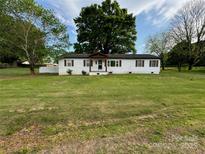 Charming single-story home with white siding, brown shutters, and a well-manicured lawn at 135 Mcshag Dr, Kannapolis, NC 28081