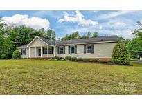 Charming single-story home featuring a covered front porch and well-maintained landscaping at 1774 Wintertide Rd, Jefferson, SC 29718