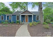 Charming blue home boasts a well-manicured yard and inviting entryway at 1933 Thurmond Pl, Charlotte, NC 28205