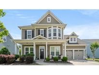 Charming two-story home featuring manicured landscaping, a welcoming front porch, and an attached two-car garage at 1963 Felts Pkwy, Fort Mill, SC 29715