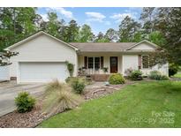 Charming single-story home featuring a well-manicured lawn and attached two-car garage at 204 Millwheel Ln, Mount Gilead, NC 27306