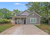 Charming gray home featuring a quaint front porch and well-maintained lawn at 205 E Maine Ave, Bessemer City, NC 28016