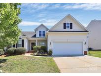 Charming two-story home with a well-manicured lawn, blooming flowerbeds, and a two-car garage at 2111 Savoy Pl, Fort Mill, SC 29707