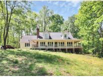 Charming home with a large covered front porch, nestled among mature trees, exudes southern comfort at 2780 China Grove Rd, Kannapolis, NC 28083