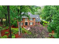 Beautiful brick home featuring mature landscaping, a black door, and black shutters at 3804 Bellingham Ln, Charlotte, NC 28215