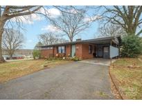 Charming one-story brick home with a covered carport and well-maintained front yard at 401 Clover Ln, Newton, NC 28658