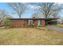 Charming brick home with a covered carport and a cozy front porch, set in a tranquil tree-lined neighborhood at 401 Clover Ln, Newton, NC 28658