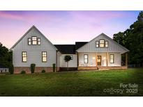 Charming exterior of a two-story home with a well-manicured lawn and inviting front porch with rocking chairs at 4453 Buffalo Shoals Rd, Maiden, NC 28650