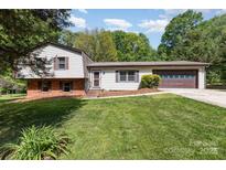 Split-level home boasts a well-maintained lawn, brick accents, and attached two-car garage at 503 Randa Dr, Statesville, NC 28625