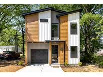 Modern two-story home featuring mixed siding, a black garage door, and professional landscaping at 620 Palmer Sw Ave, Concord, NC 28027