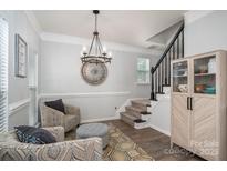 Bright living room showcases stylish seating arrangement, staircase, and elegant decor at 7905 Sedgebrook E Dr, Stanley, NC 28164