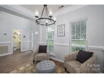 Comfortable living room featuring natural light, stylish seating, and modern chandelier at 7905 Sedgebrook E Dr, Stanley, NC 28164