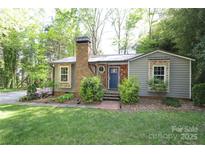 Charming home featuring a brick chimney, blue front door, and beautifully landscaped front yard at 8903 New Town Rd, Waxhaw, NC 28173