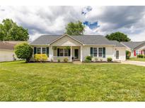 Charming single-story home featuring green shutters, a cozy front porch, and a lush green lawn at 9916 Meadowmead Ct # 17, Charlotte, NC 28273