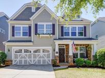 Charming two-story home with a front porch, stone accents, and a two-car garage at 1020 Equipoise Dr, Indian Trail, NC 28079