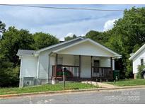 Charming home featuring a cozy front porch, white siding, and a well-maintained lawn at 1025 Martin Luther King Jr Dr, Albemarle, NC 28001