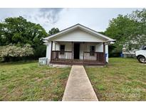 Charming home featuring a covered front porch and a well-maintained lawn, perfect for outdoor relaxation and curb appeal at 1025 Martin Luther King Jr Dr, Albemarle, NC 28001