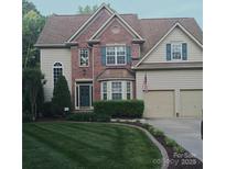 Charming two-story home featuring a brick facade, well-manicured lawn, and a two-car garage at 10316 Willingham Rd, Huntersville, NC 28078