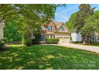 Charming two-story home with a brick facade, well-maintained lawn, and a two-car garage in a landscaped neighborhood at 10316 Willingham Rd, Huntersville, NC 28078