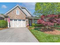 Charming home featuring a stone facade, two-car garage, and beautifully landscaped front yard at 11008 Round Rock Rd, Charlotte, NC 28277