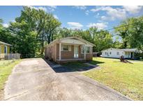 A charming one-story brick house with a covered front porch and a large concrete driveway at 1214 Short St, Salisbury, NC 28144