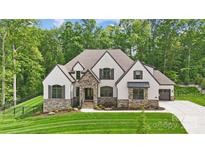 Stunning exterior of a two-story home with stone accents, neutral stucco, and a professionally landscaped yard at 13106 Bien Ct, Huntersville, NC 28078