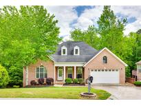 Charming brick home featuring a well-manicured lawn, mature trees, and a two-car garage at 1342 Crown Ridge Dr # 38, Fort Mill, SC 29708
