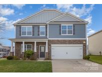 Charming two-story home featuring a stone facade, gray siding, and a well-maintained lawn at 138 Maritime St, Mooresville, NC 28117