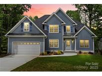 Charming two-story home with a manicured lawn, attached garage, and a combination of vertical and shingle siding at 156 Clear Springs Rd, Mooresville, NC 28115