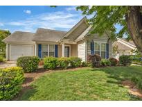 Charming single-story home boasts a well-manicured lawn, neat landscaping, and blue shutters at 2008 Taras Trace Dr, Statesville, NC 28625