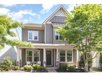 Charming two-story home featuring a covered front porch and manicured landscaping at 209 Helton Ln, Fort Mill, SC 29708