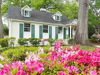 Charming home featuring blooming azaleas, green shutters, and a well-maintained landscaped yard at 3020 Hampton Ave, Charlotte, NC 28207
