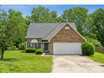 Charming brick and siding home with a two-car garage and well-manicured front lawn at 3038 Twin Peaks Ct, Monroe, NC 28110